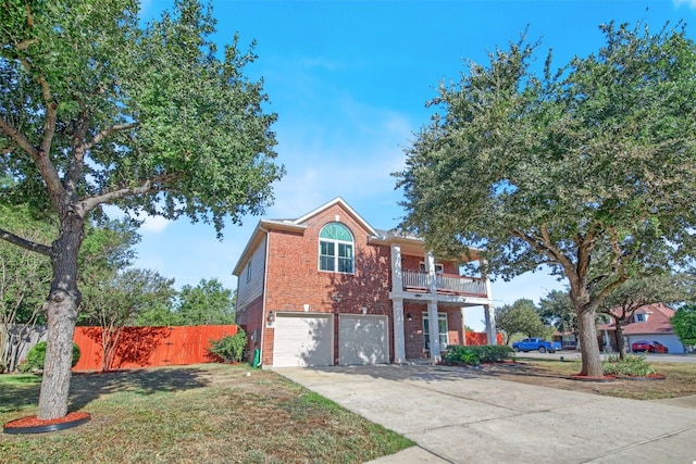 view of front of property with a garage, a balcony, and a front yard