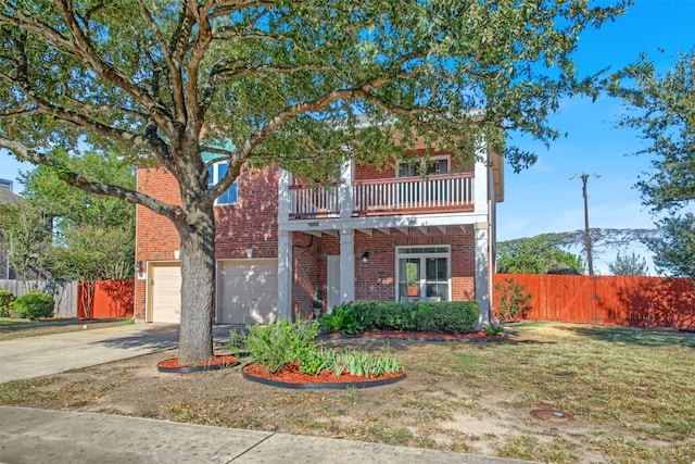 view of front of property featuring a balcony, a garage, and a front lawn