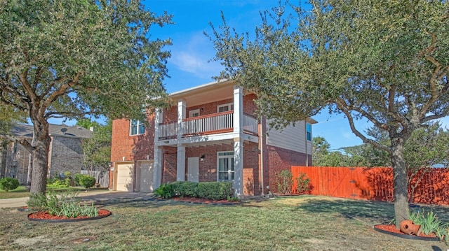 view of front facade with a garage, a balcony, and a front yard