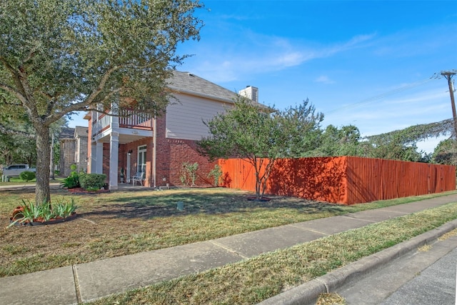 view of home's exterior featuring a yard and a balcony