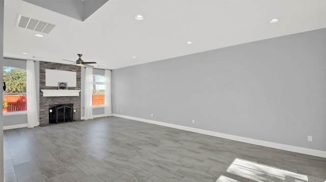 unfurnished living room with ceiling fan and a fireplace