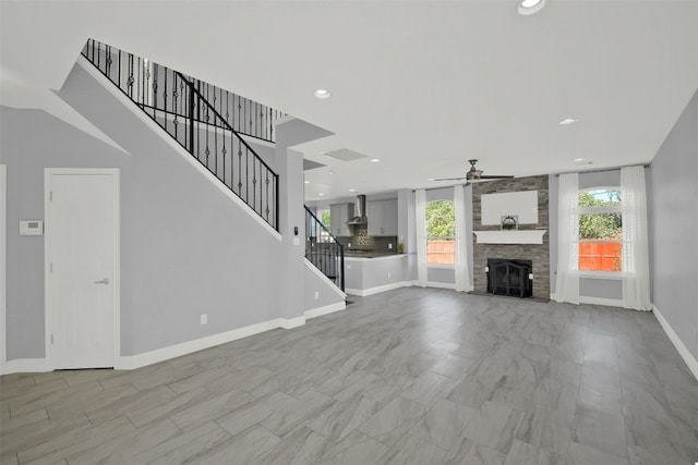 unfurnished living room featuring a fireplace and ceiling fan