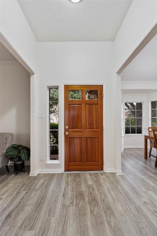 entrance foyer with a textured ceiling and light wood-type flooring