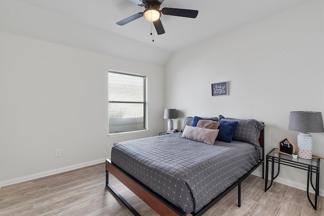 bedroom with ceiling fan, light hardwood / wood-style flooring, and vaulted ceiling