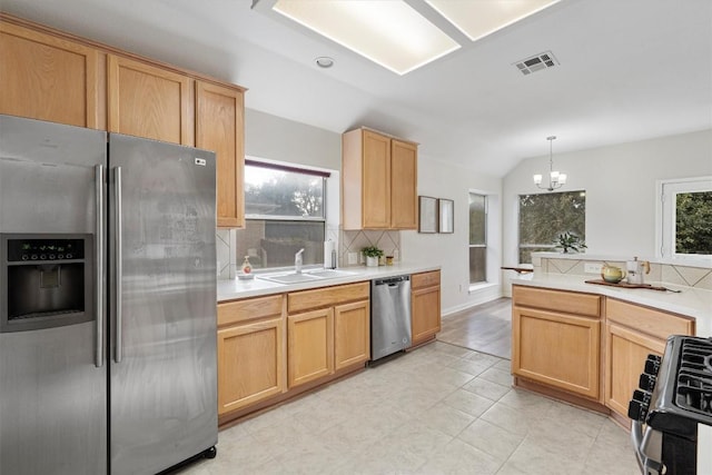 kitchen featuring sink, an inviting chandelier, plenty of natural light, pendant lighting, and appliances with stainless steel finishes