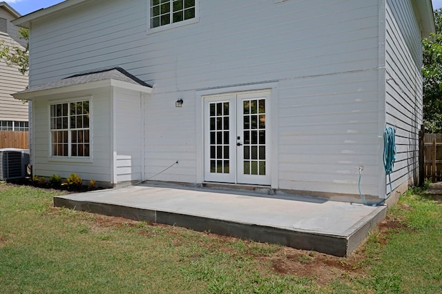 rear view of property featuring a patio, central AC unit, a yard, and french doors