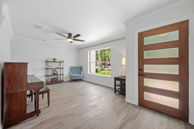 sitting room with ornamental molding, ceiling fan, and light wood-type flooring