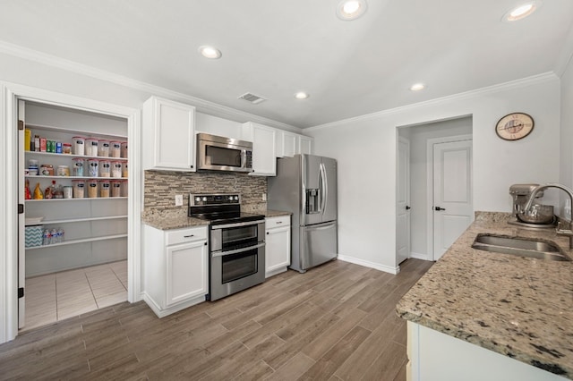 kitchen featuring white cabinetry, sink, light stone countertops, and appliances with stainless steel finishes