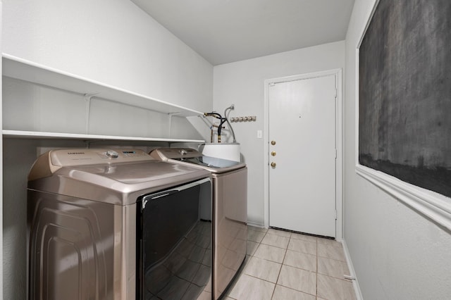 laundry area with washer and dryer and light tile patterned flooring