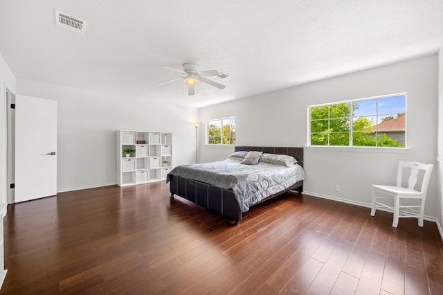 bedroom with dark hardwood / wood-style floors and ceiling fan