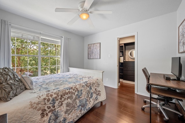 bedroom with ceiling fan, dark hardwood / wood-style floors, and a textured ceiling