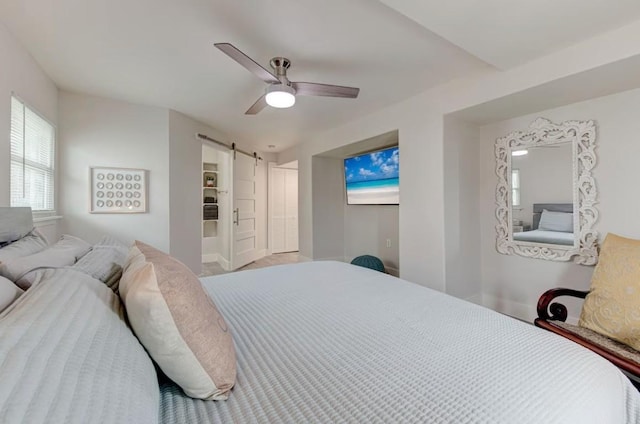 bedroom with a barn door and ceiling fan