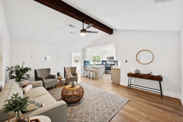 living room featuring lofted ceiling with beams, ceiling fan, and light hardwood / wood-style flooring