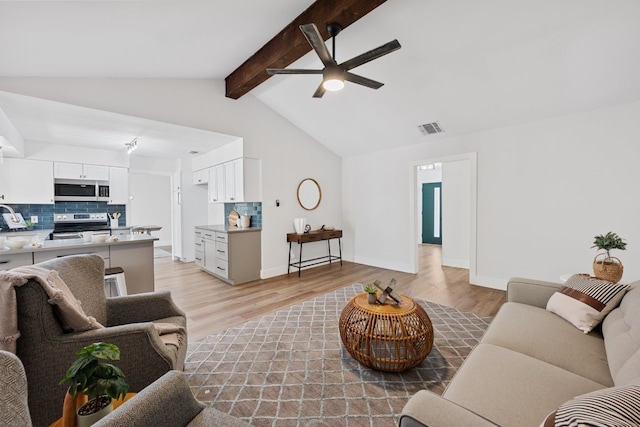 living room featuring ceiling fan, lofted ceiling with beams, and light hardwood / wood-style floors