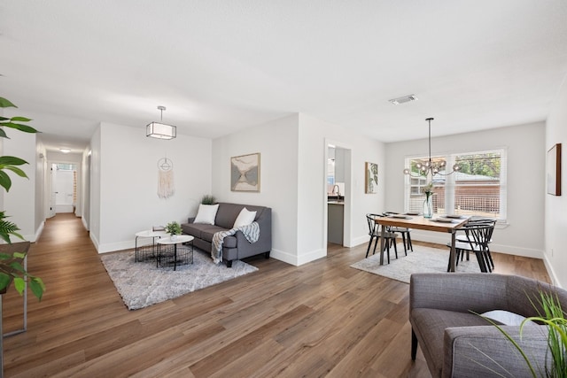 living room with an inviting chandelier and hardwood / wood-style flooring