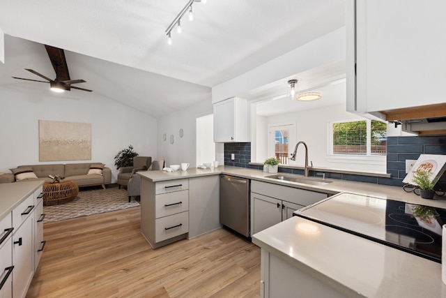 kitchen featuring kitchen peninsula, stainless steel dishwasher, sink, light hardwood / wood-style floors, and white cabinetry