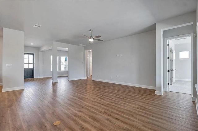 unfurnished living room with dark hardwood / wood-style floors and ceiling fan