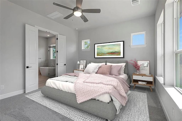 carpeted bedroom with ceiling fan, ensuite bath, and multiple windows