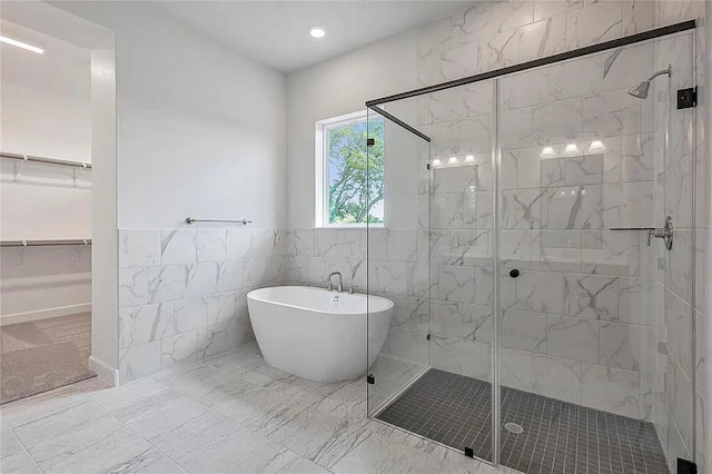 bathroom featuring tile walls and shower with separate bathtub