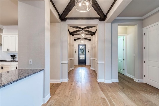 entryway with light wood-type flooring, coffered ceiling, beamed ceiling, and baseboards