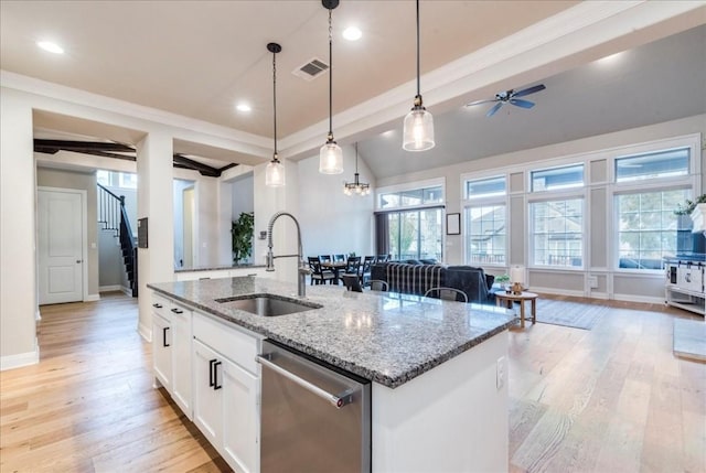 kitchen featuring visible vents, dishwasher, an island with sink, open floor plan, and a sink