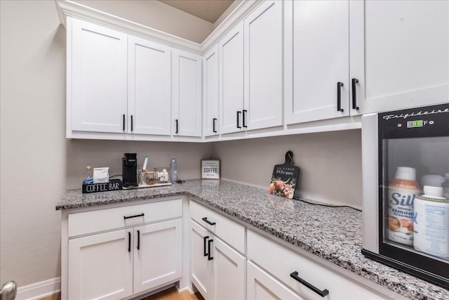 kitchen featuring white cabinetry and light stone counters