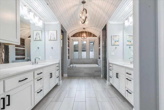 full bathroom with vaulted ceiling, two vanities, a sink, and an inviting chandelier