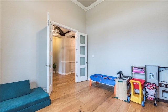 rec room with ornamental molding, french doors, baseboards, and wood finished floors