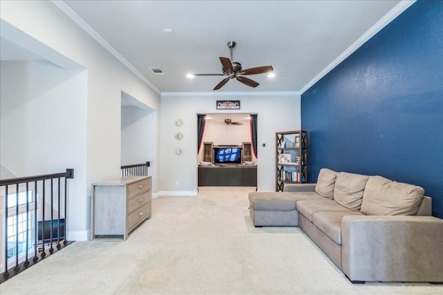 carpeted living area featuring ornamental molding, a ceiling fan, visible vents, and baseboards