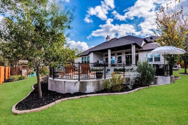 rear view of house with a patio area, a chimney, fence, and a yard