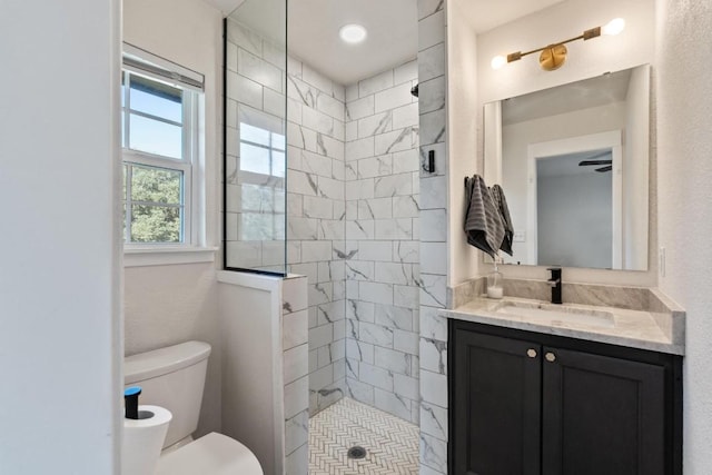 bathroom featuring tiled shower, vanity, and toilet