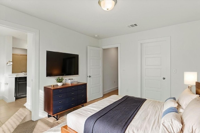 tiled bedroom featuring ensuite bathroom