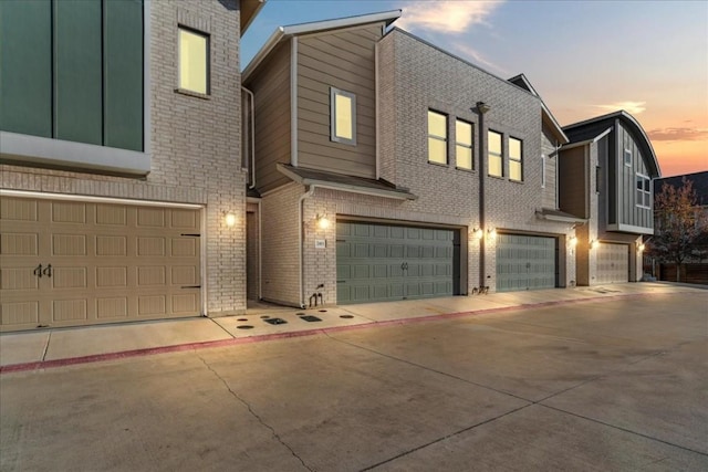 7411 Merrick Ln Unit 39, Austin, TX 78745 - view of front facade with an attached garage, brick siding, and concrete driveway