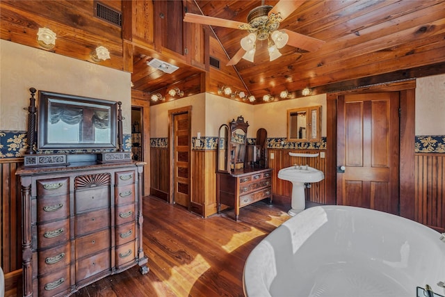 bathroom with lofted ceiling, wood ceiling, wood-type flooring, a tub, and ceiling fan