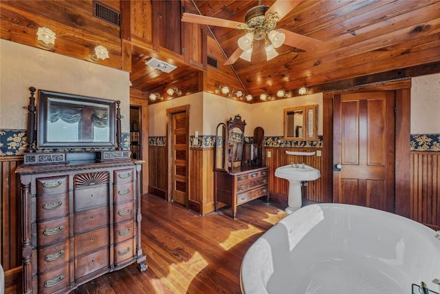 524 Saint Peter St, Gonzales, TX 78629 - bedroom with vaulted ceiling, dark wood finished floors, a wainscoted wall, wooden ceiling, and wooden walls