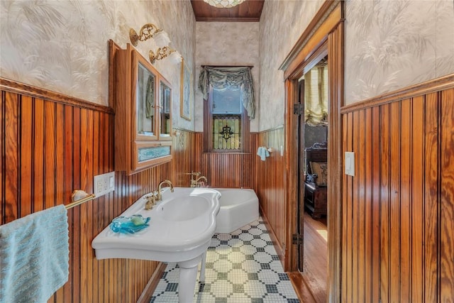 524 Saint Peter St, Gonzales, TX 78629 - bathroom with wallpapered walls, wainscoting, and wooden walls