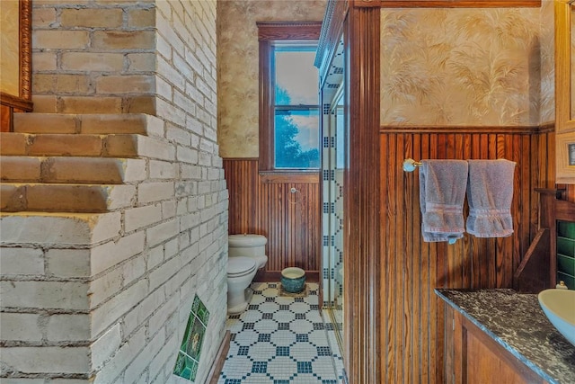 524 Saint Peter St, Gonzales, TX 78629 - bathroom featuring wainscoting, vanity, wood walls, and tile patterned flooring