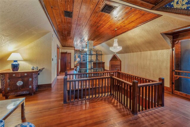 524 Saint Peter St, Gonzales, TX 78629 - staircase with wood-type flooring, lofted ceiling, a textured wall, and wooden ceiling