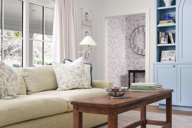 living room with built in shelves and light hardwood / wood-style floors