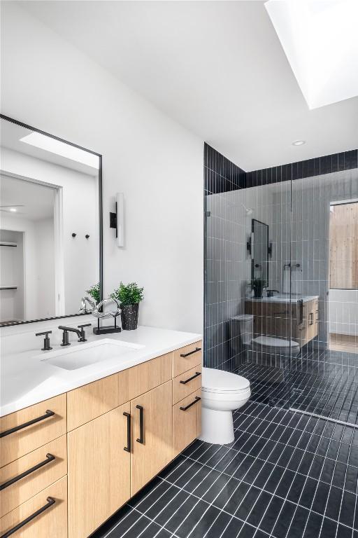 full bathroom with tile patterned flooring, a shower stall, toilet, and vanity