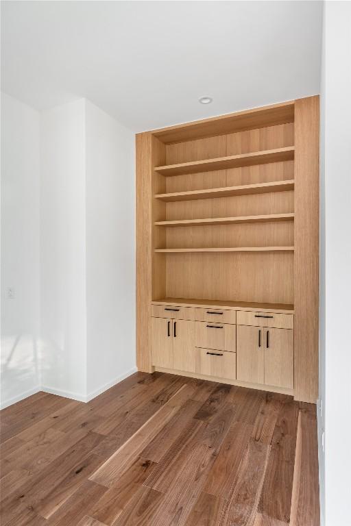 interior space featuring baseboards, dark wood finished floors, and built in features