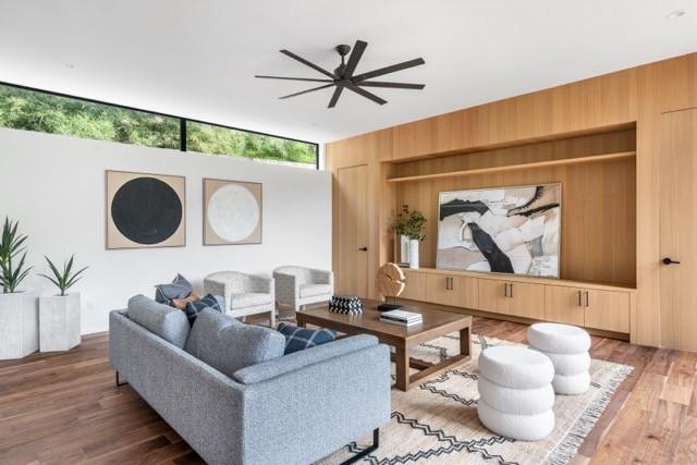 living area with wooden walls and wood finished floors