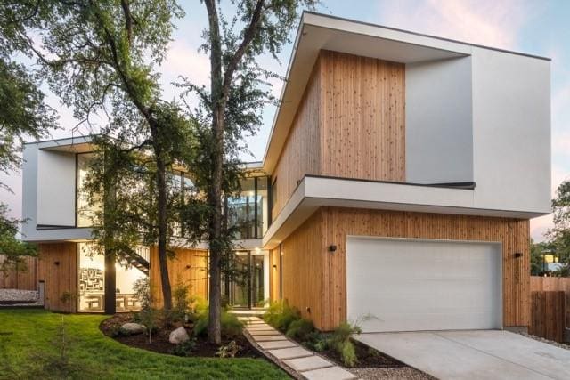 contemporary home featuring a garage, a front lawn, and concrete driveway