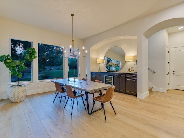 dining room with a chandelier, light wood-type flooring, and wine cooler