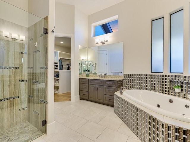 bathroom featuring tile patterned floors, vanity, and shower with separate bathtub