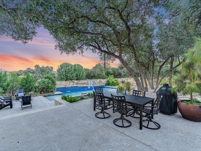 patio terrace at dusk featuring grilling area