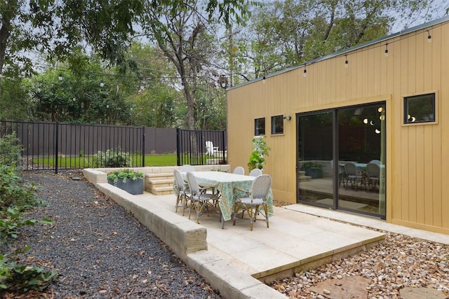 view of patio featuring outdoor dining space and fence