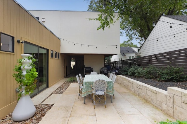 view of patio with outdoor dining space and fence