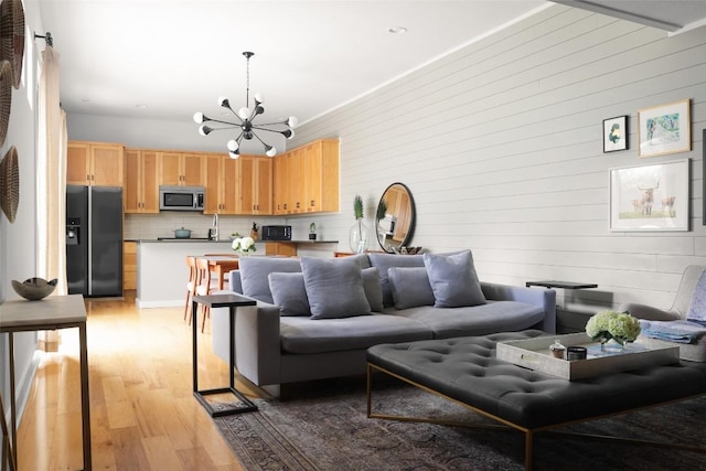 living room featuring an inviting chandelier and light wood-style floors