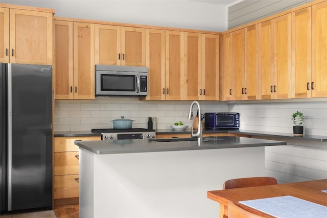 kitchen featuring decorative backsplash, light brown cabinetry, and stainless steel appliances